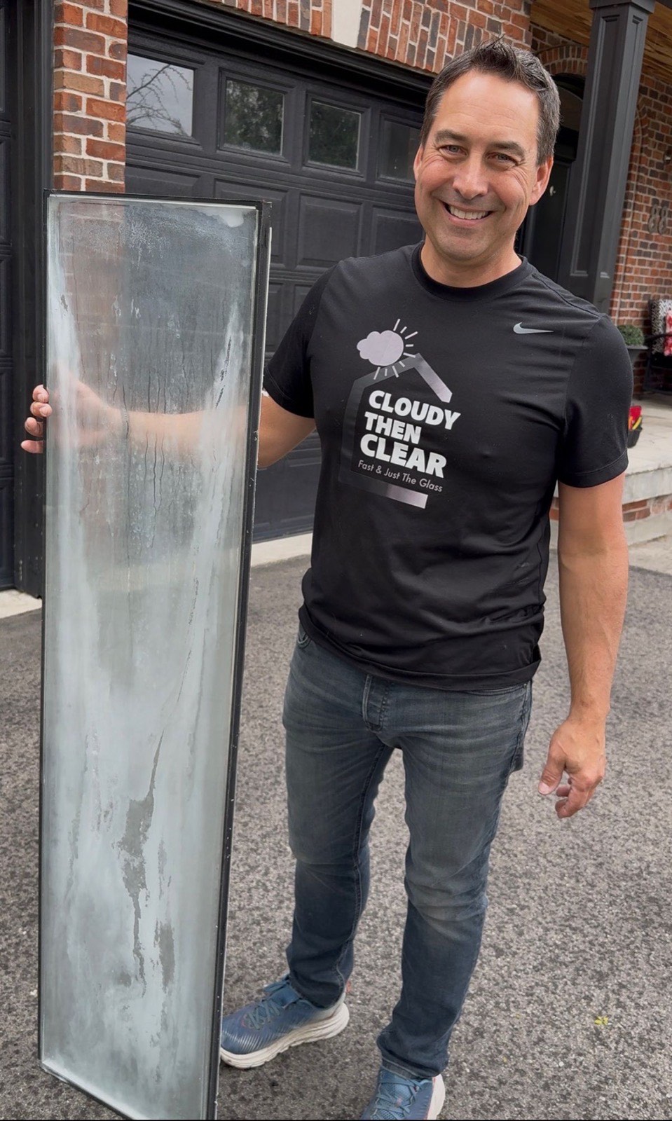 Ryan from Cloudy Then Clear holding a fogged sealed glass unit freshly removed from its frame